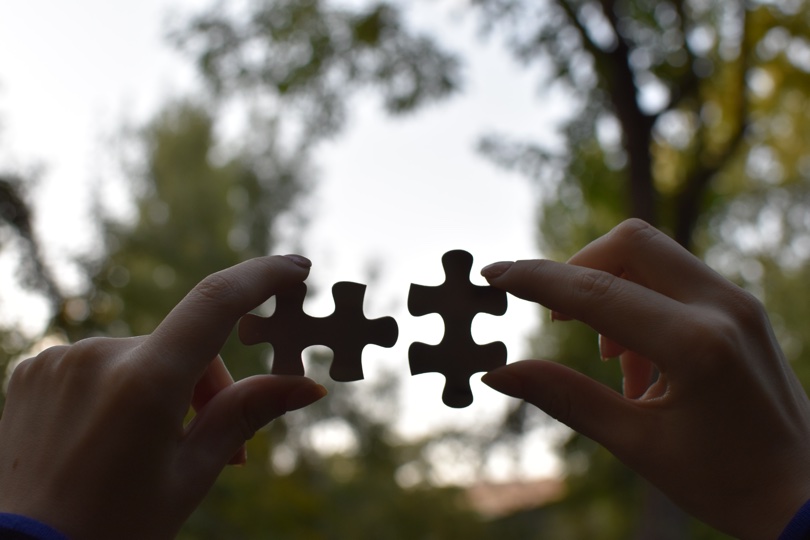 Female hands holding 2 pieces of a puzzle