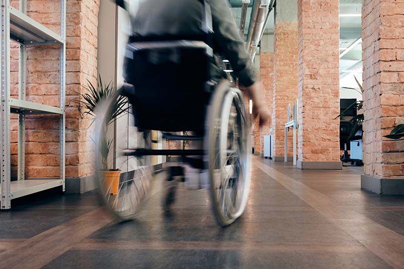 Pessoa a andar numa cadeira de rodas num corredor de escritório